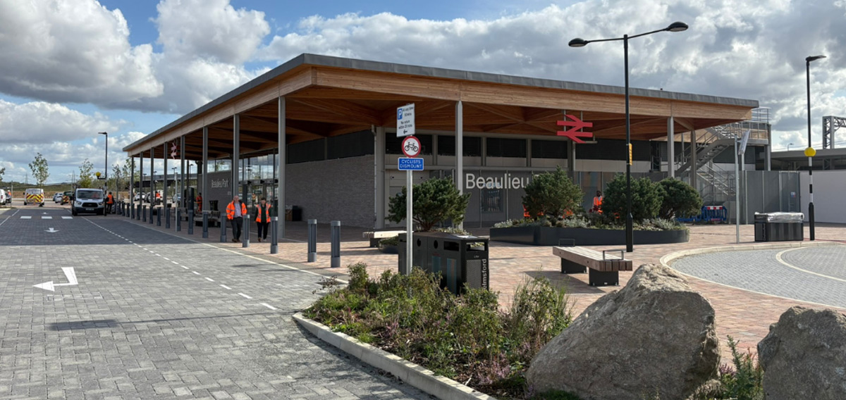 Indoor station concourse with departure boards, seating and tactile paving